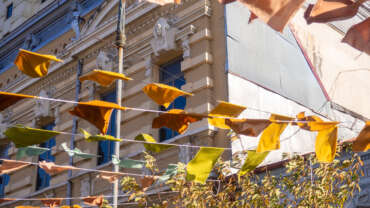 Flags over the street. City celebration concept. Warm colors. Scenery over the street. Festival